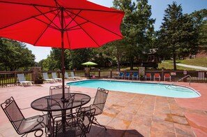 A swimming pool with a red umbrella, lounge chairs, and a patio area with a table and chairs. - Wilderness Retreat Cabin- Lg Game Room, Private Hot Tub; 1 Mile to Thunder Ridge (Ridgedale)