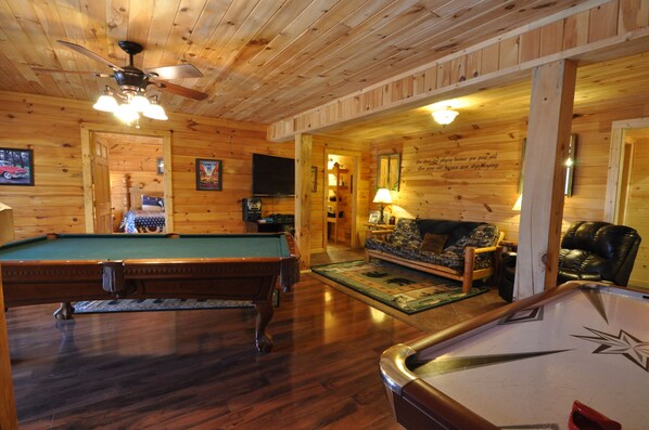 A wooden interior with a pool table, a sofa, and a billiards table. - Wilderness Retreat Cabin- Lg Game Room, Private Hot Tub; 1 Mile to Thunder Ridge (Ridgedale)