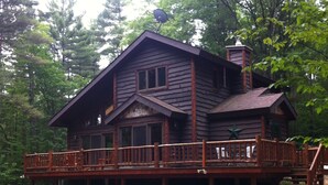 A log cabin with a wooden deck and a large star decoration. - Bright cabin retreat happily situated 7 miles from Whiteface Mt (Jay)