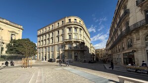 Un edificio storico con una facciata curva, ampie finestre e un ingresso imponente.