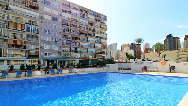 Una piscina con vista su un condominio a più piani sullo sfondo.