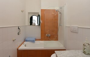 Tina con regadera, secadora de cabello, bidet, toallas 