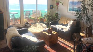 Ein Wohnzimmer mit Meerblick, inklusive Sofa, Couchtisch und Ventilator.