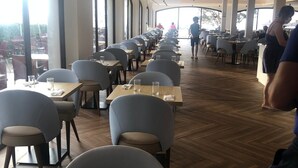 A spacious dining area with long tables and chairs, large windows, and a high ceiling with recessed lighting. - 2 Bedroom, 2 bathroom front line property in Cala D'or (07660 Cala D'or)