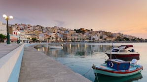A waterfront scene with boats docked, a promenade, and buildings in the background. - The Old Pomegranate House - Sea view - AC - WIFI (Mirsini)