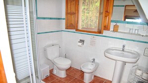 Une salle de bain équipée de toilettes, d’un bidet et d’un lavabo.