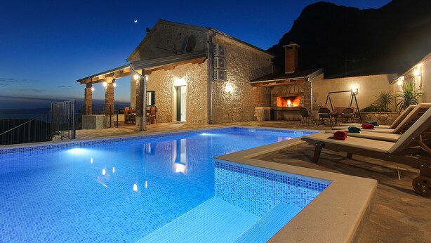 A swimming pool with lounge chairs and a stone building with a fireplace. - NEW! Stone house in quiet location, heated pool + sea views, ideal for familys (Zivogosce)