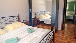 Une chambre à coucher comprenant un lit, une table de chevet, un miroir et une armoire.