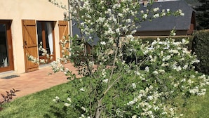 Een huis met een tuin, een houten deur en een raam met gordijn.