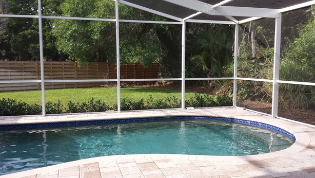 A swimming pool with a clear blue water, surrounded by a white fence and a tiled deck. - Luxury, New Home - Serene and Private Vacation Oasis - Minutes from Siesta Key! (Sarasota)