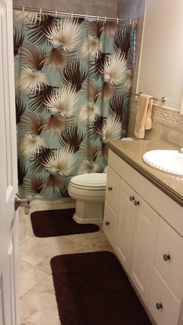 Une salle de bain avec des toilettes, un lavabo et un rideau de douche.