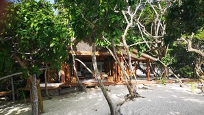 A wooden structure with a covered porch, surrounded by trees and sand. - Isla Venado. Private Island in Cholon, Cartagena. (Cartagena)