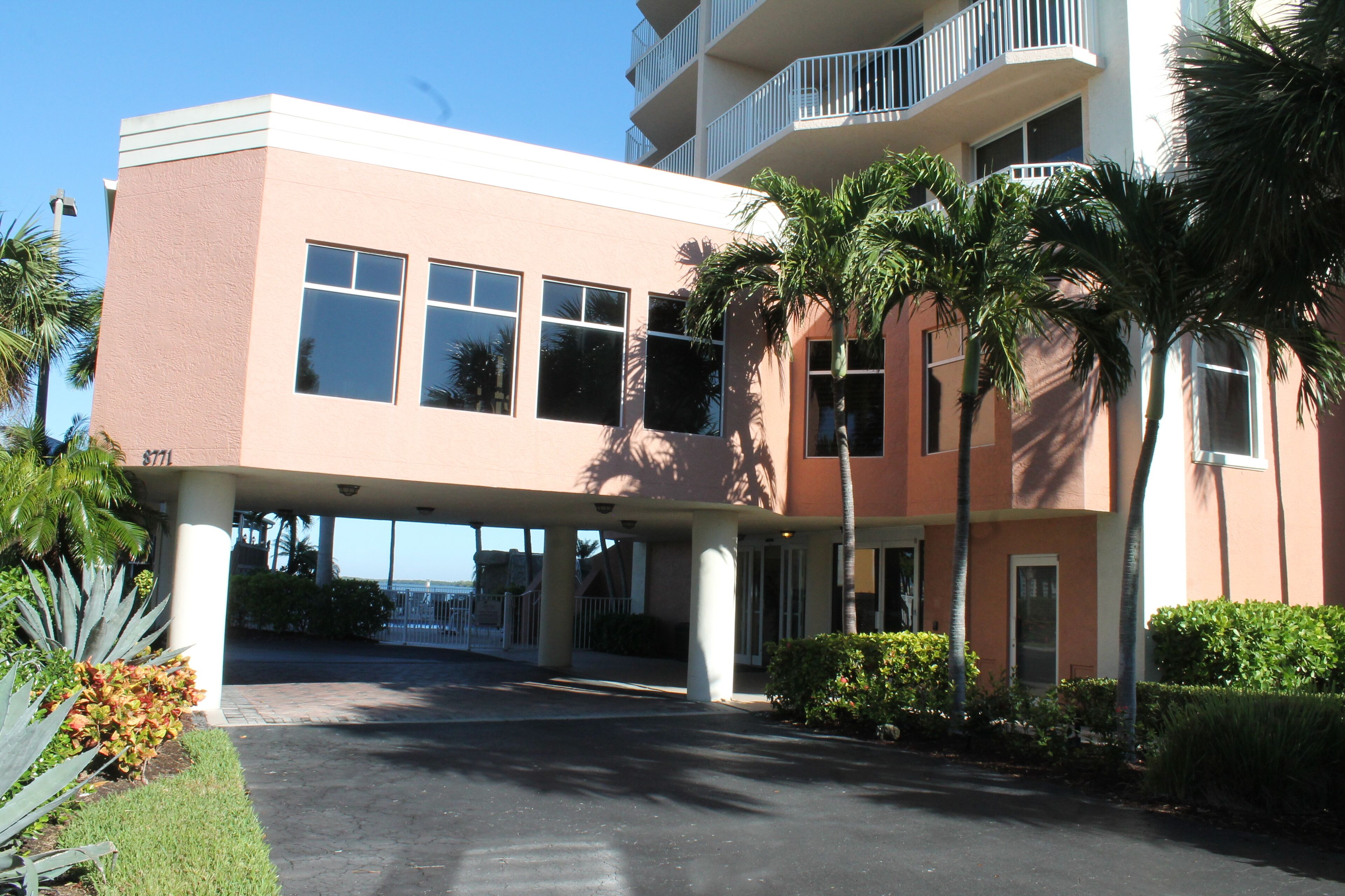 A multi-story hotel with a flat roof, large windows, and a covered entrance area.