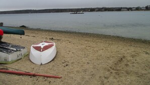 Une plage de sable avec un petit bateau et un canoë.