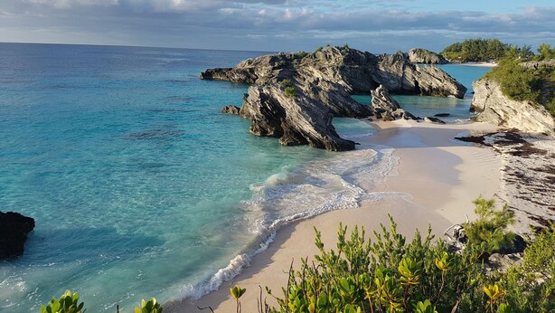 A beach with clear turquoise waters, rocky formations, and greenery. - Amazing Property Close To Beaches/Golf Course/Railway Trails (Warwick)