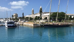 A marina with boats docked, a historic building with a clock tower, and a clear blue sky. - Amazing Property Close To Beaches/Golf Course/Railway Trails (Warwick)