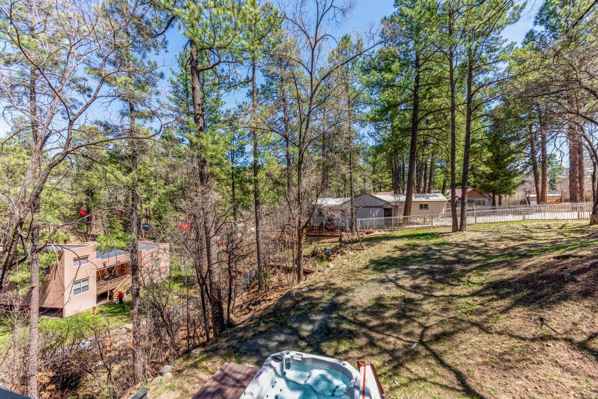 A residential area with a house, a fenced yard, and a hot tub.