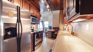 A modern kitchen with stainless steel appliances, wooden cabinets, and a central island. - Ocean View Condo located within Bermuda Beach - Gold Standard Approved (San Pedro)