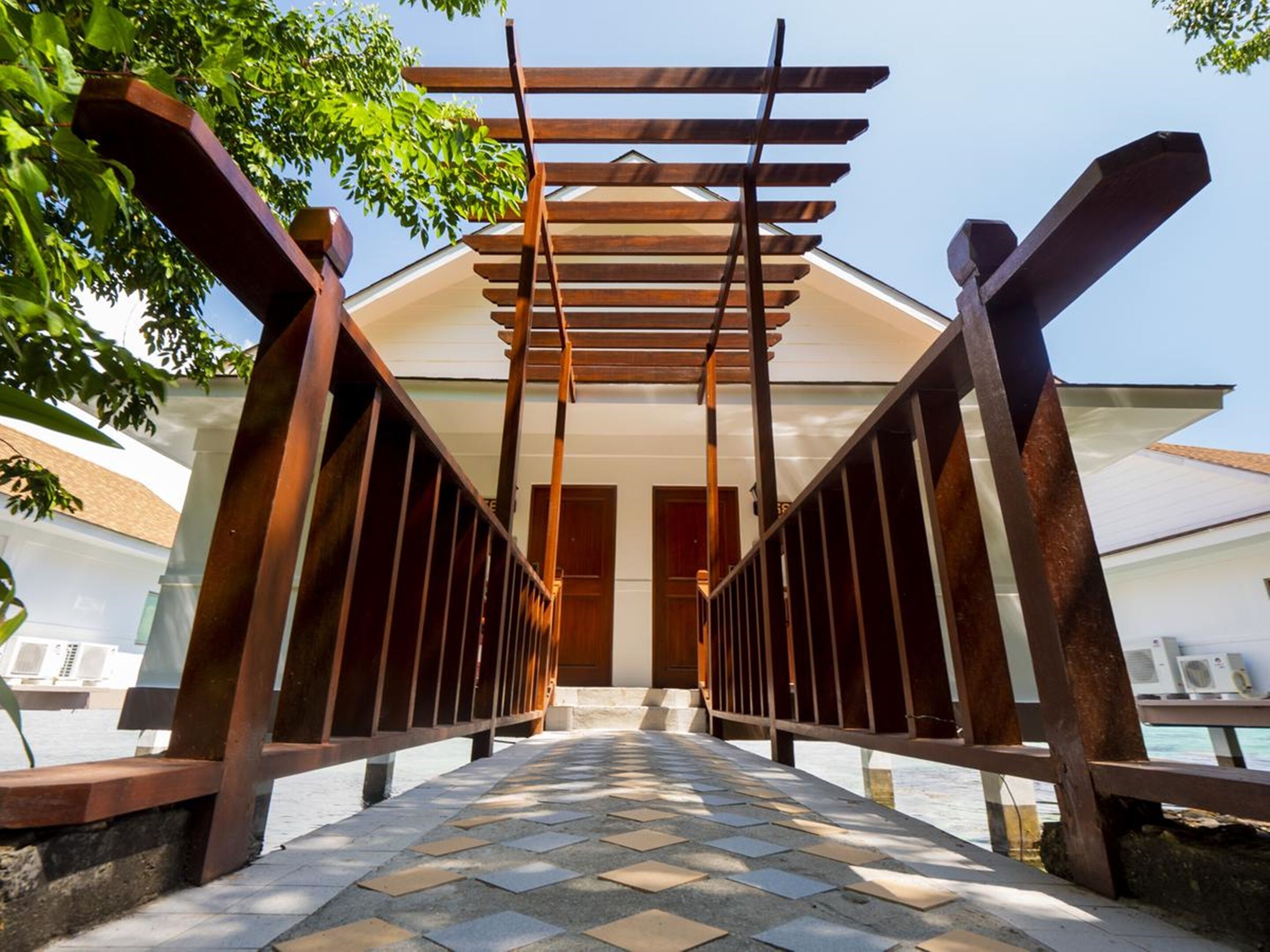 Un passage couvert, doté d’un sol carrelé, qui mène à l’entrée d’un bâtiment.