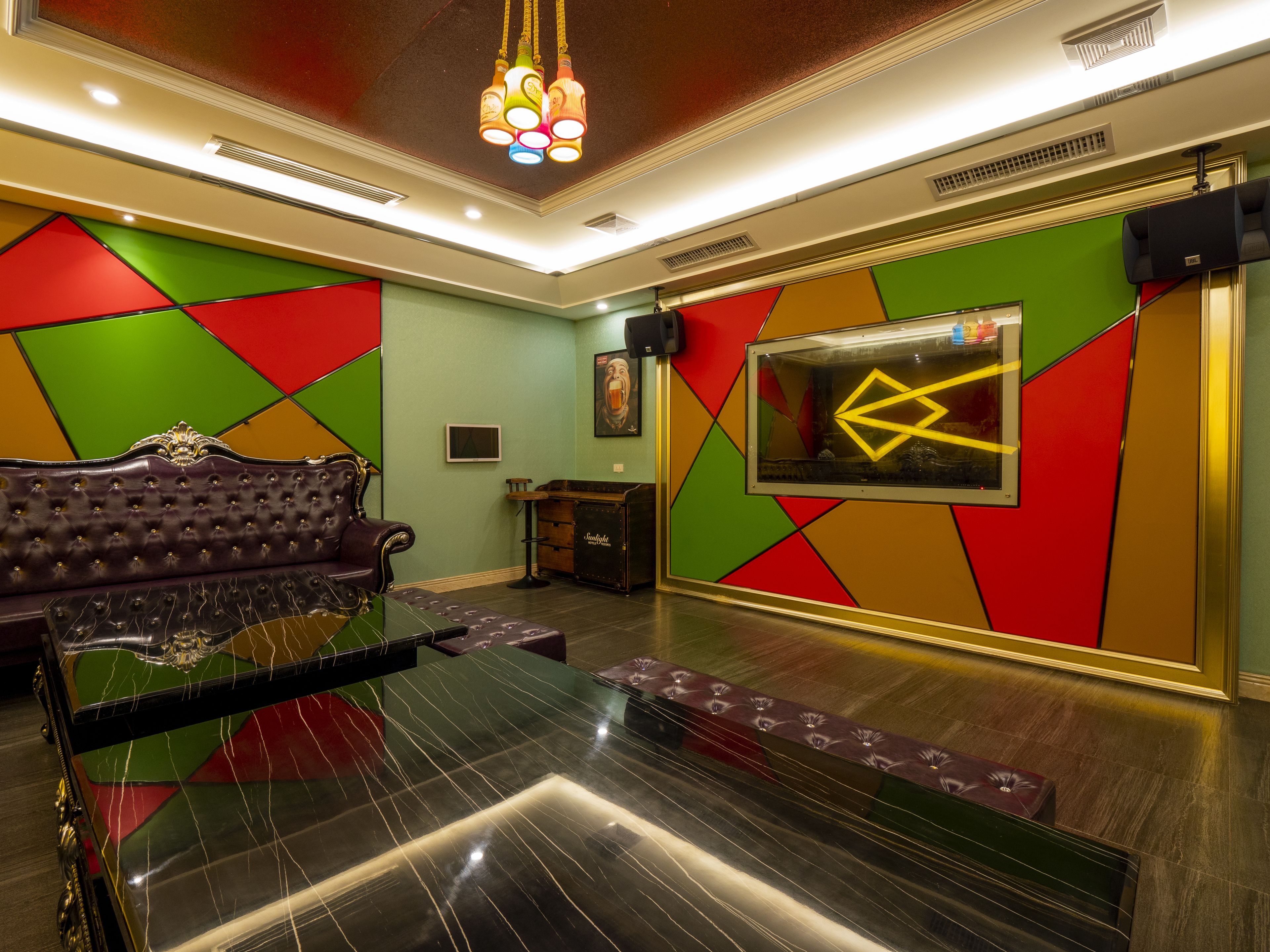A room with a plush leather sofa, a glass-top coffee table, and a geometric-patterned wall.