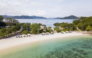 En la playa, arena blanca, sombrillas, toallas de playa
