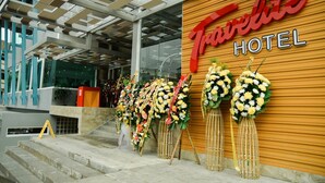 A Travelite Hotel entrance with a modern design, featuring a wooden facade and a glass entrance. - Travelite Hotel Legarda (Baguio)