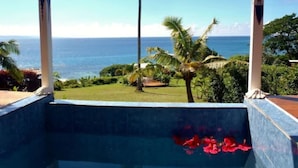 A pool with a view of the ocean and palm trees. - Makaira Resort (Taveuni Island East)