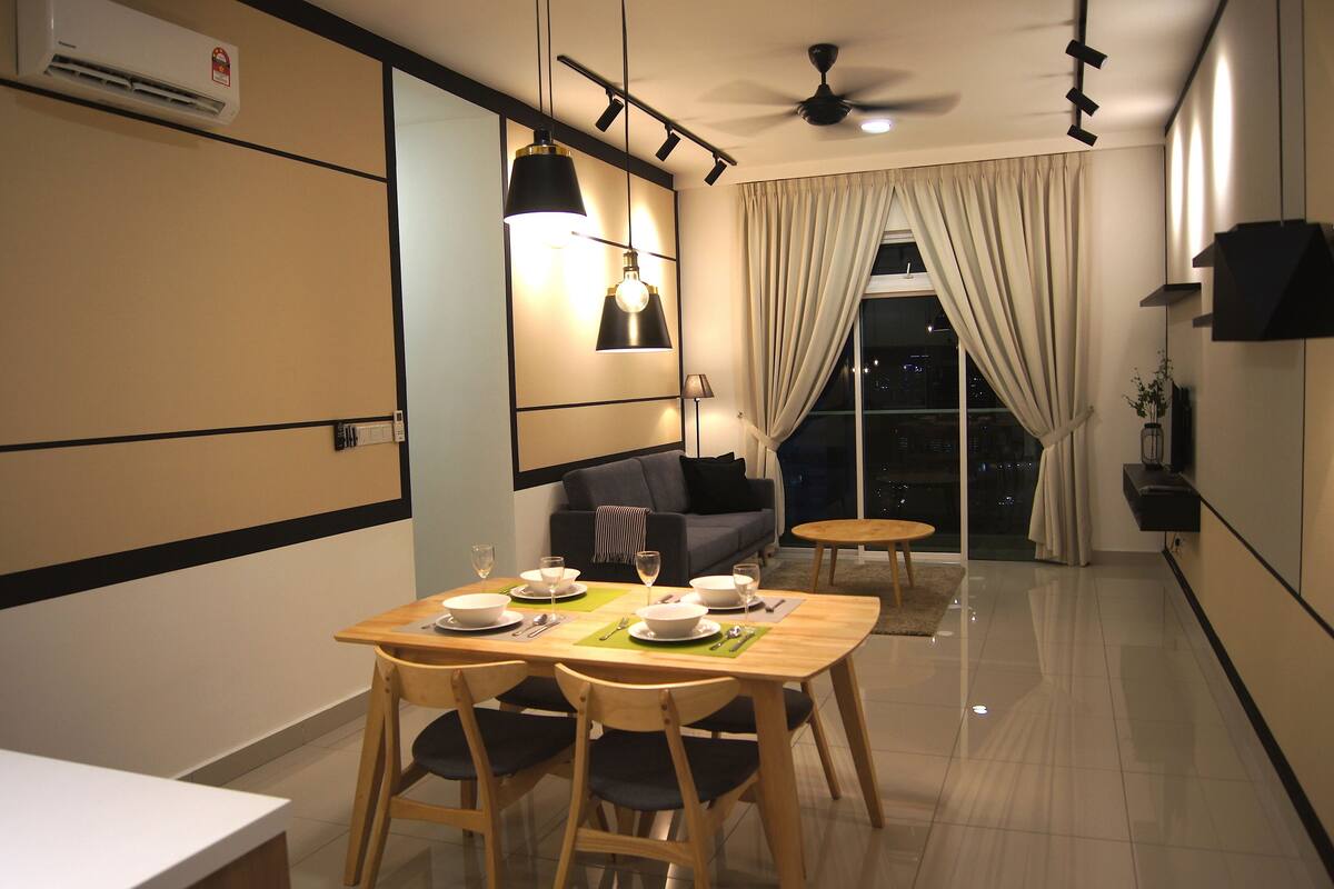 A modern dining area with a table set for four, a sofa, and a ceiling fan.
