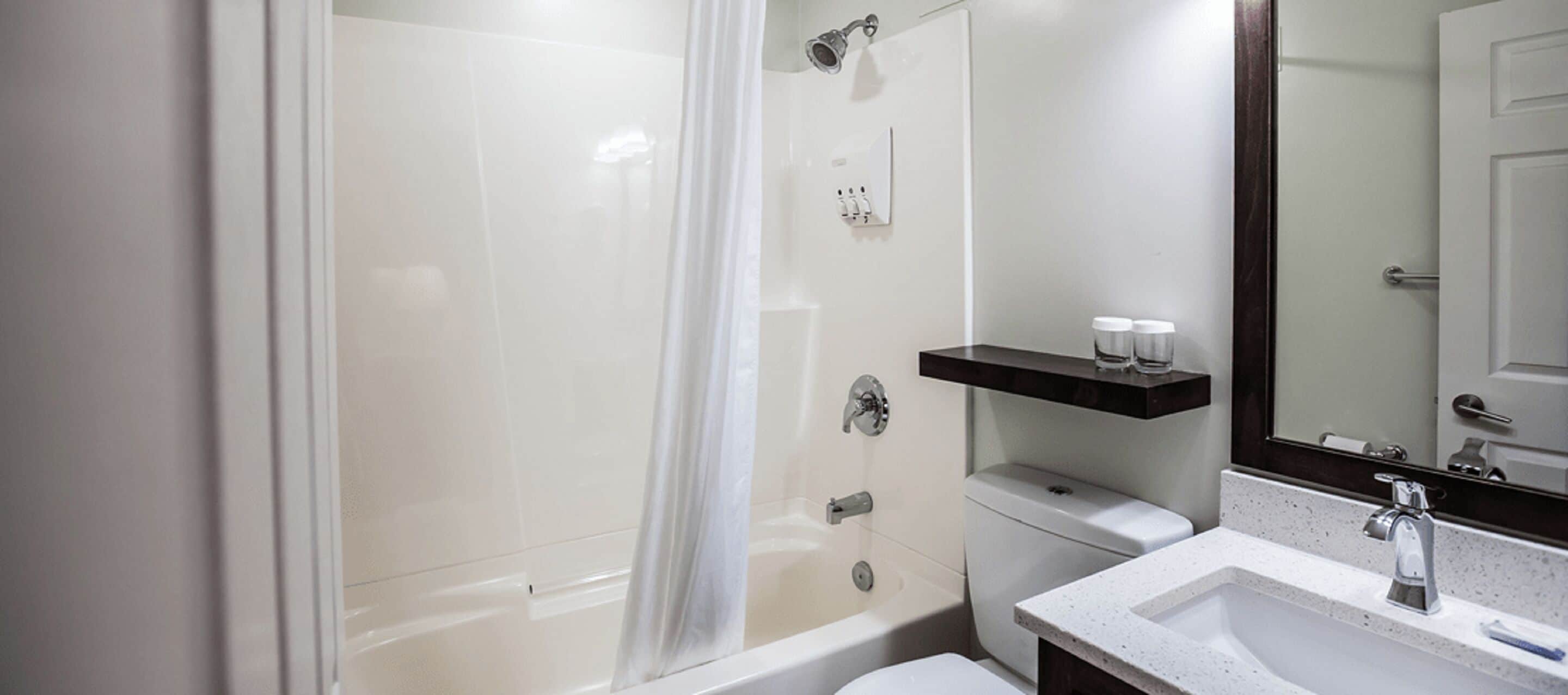 A modern bathroom with a glass-enclosed shower, a white sink, and a mirror above the sink.