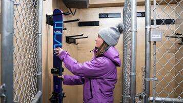 A person in a purple coat interacting with a ski lift.