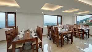 Un comedor con techo alto, ventanas amplias y vistas a las montañas.
