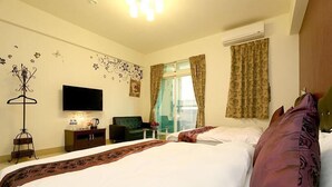 Una habitación de hotel con cama, televisión, escritorio y ventana con cortinas.