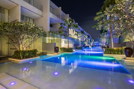 Una piscina al aire libre, sillones reclinables de piscina