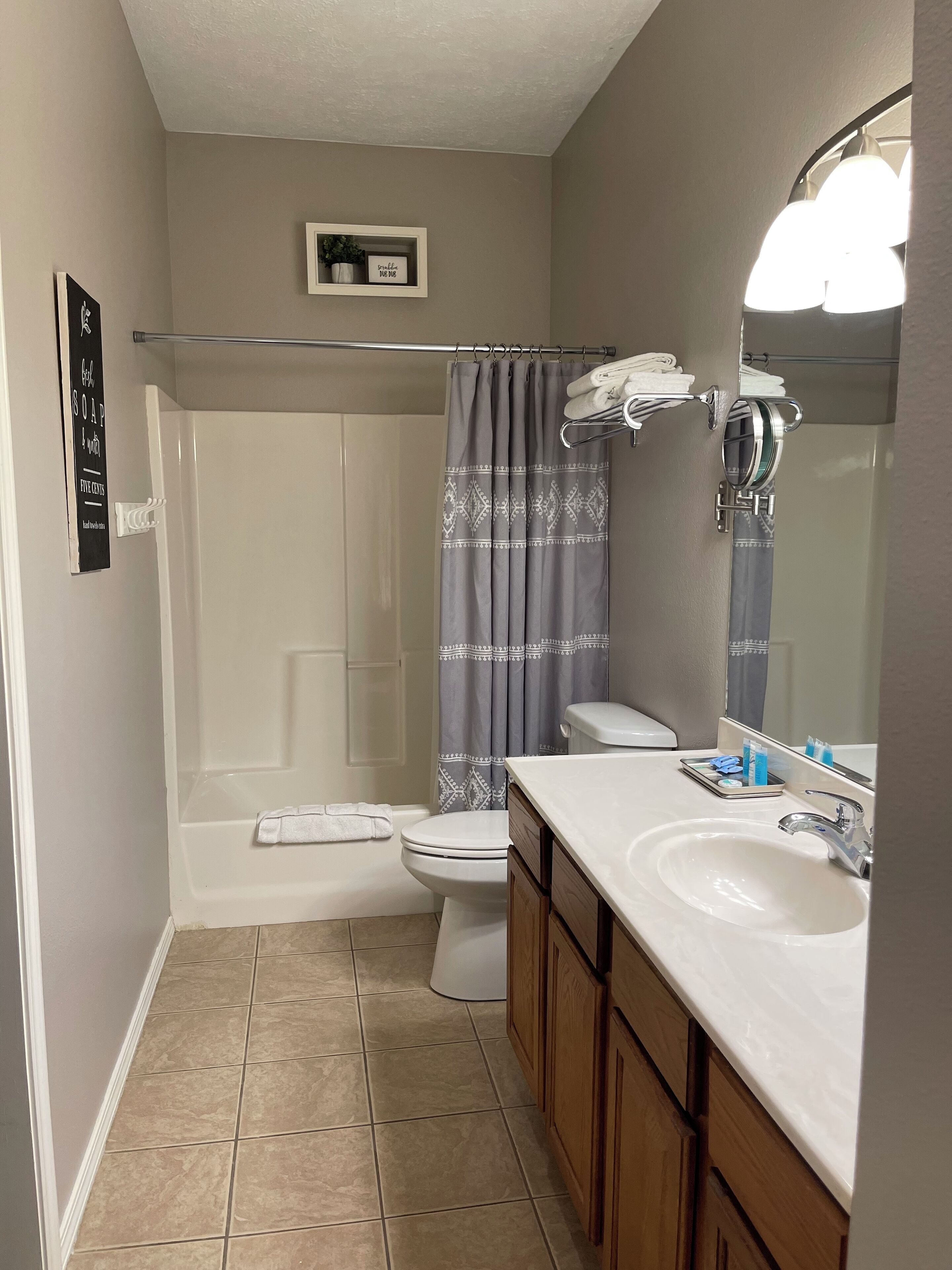 A bathroom with a shower, toilet, and sink.