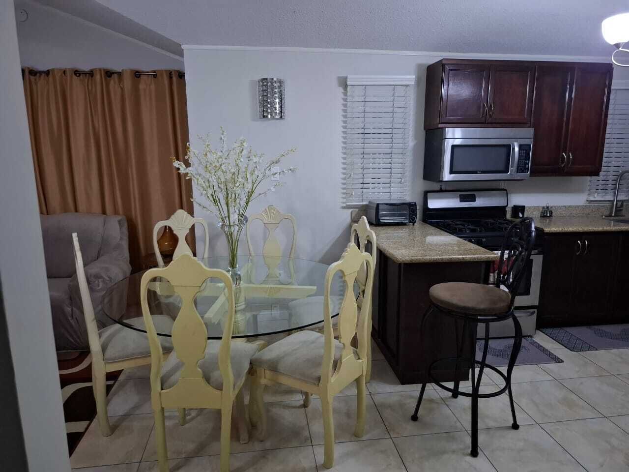 A compact living space with a dining area, kitchen, and a sofa.