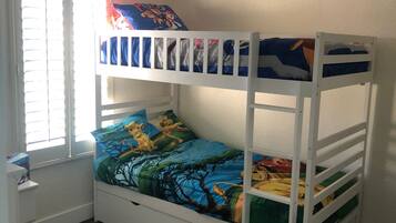 Cozy bedroom with a bunk bed setup, featuring a ceiling fan and a window with blinds.