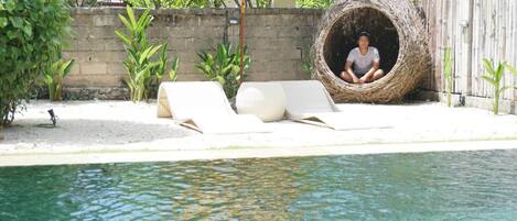 Alberca al aire libre y camastros