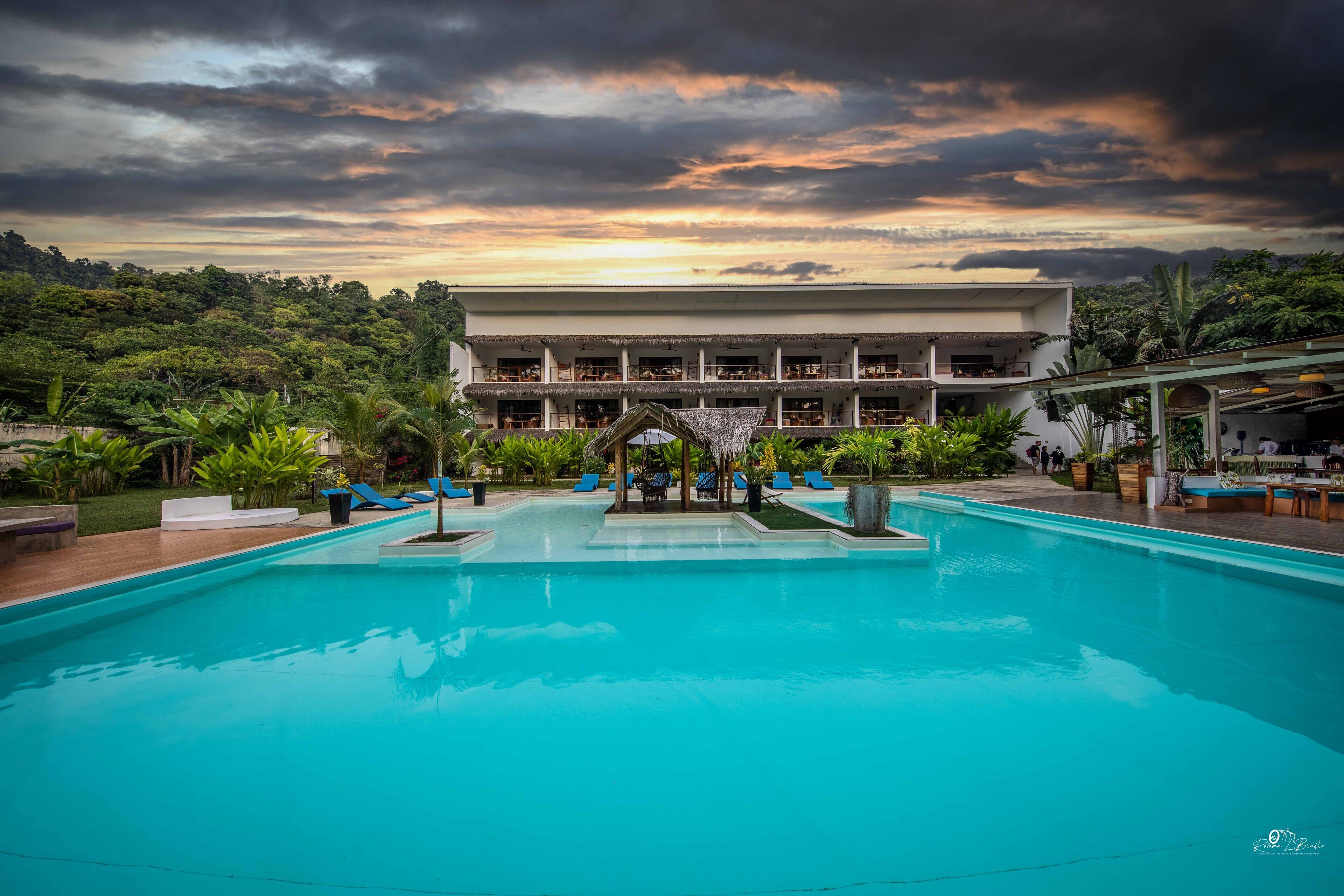 Una piscina al aire libre, sillones reclinables de piscina
