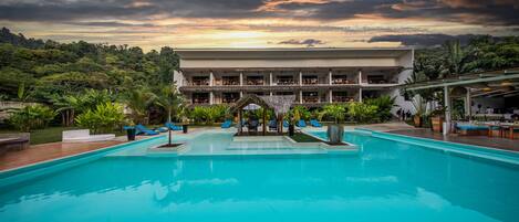 A swimming pool with lounge chairs and a building in the background.