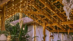 A cozy outdoor seating area with a swing chair, string lights, and lush greenery. - El Nido Moringa Resort (El Nido)