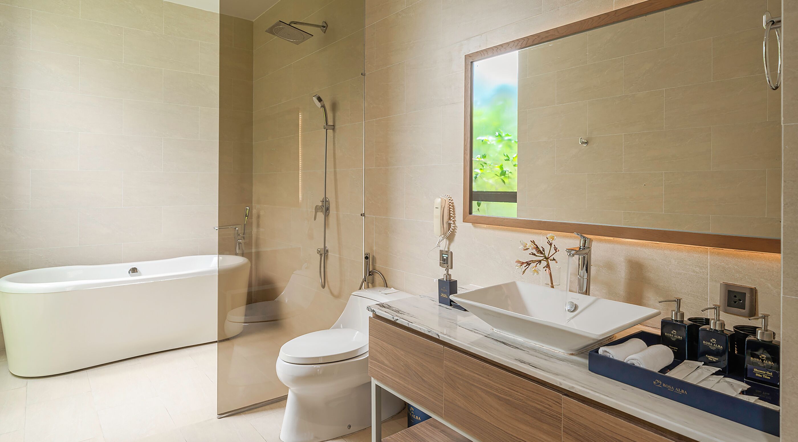 Een moderne badkamer met een vrijstaand bad, een toilet, een wastafel met spiegel en een douchehoek.