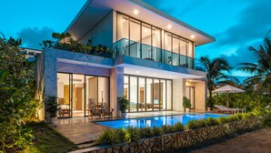 A modern two-story house with a glass balcony, a swimming pool, and lush greenery. - Rosa Alba Resort & Villas Tuy Hoa (Tuy Hoa)