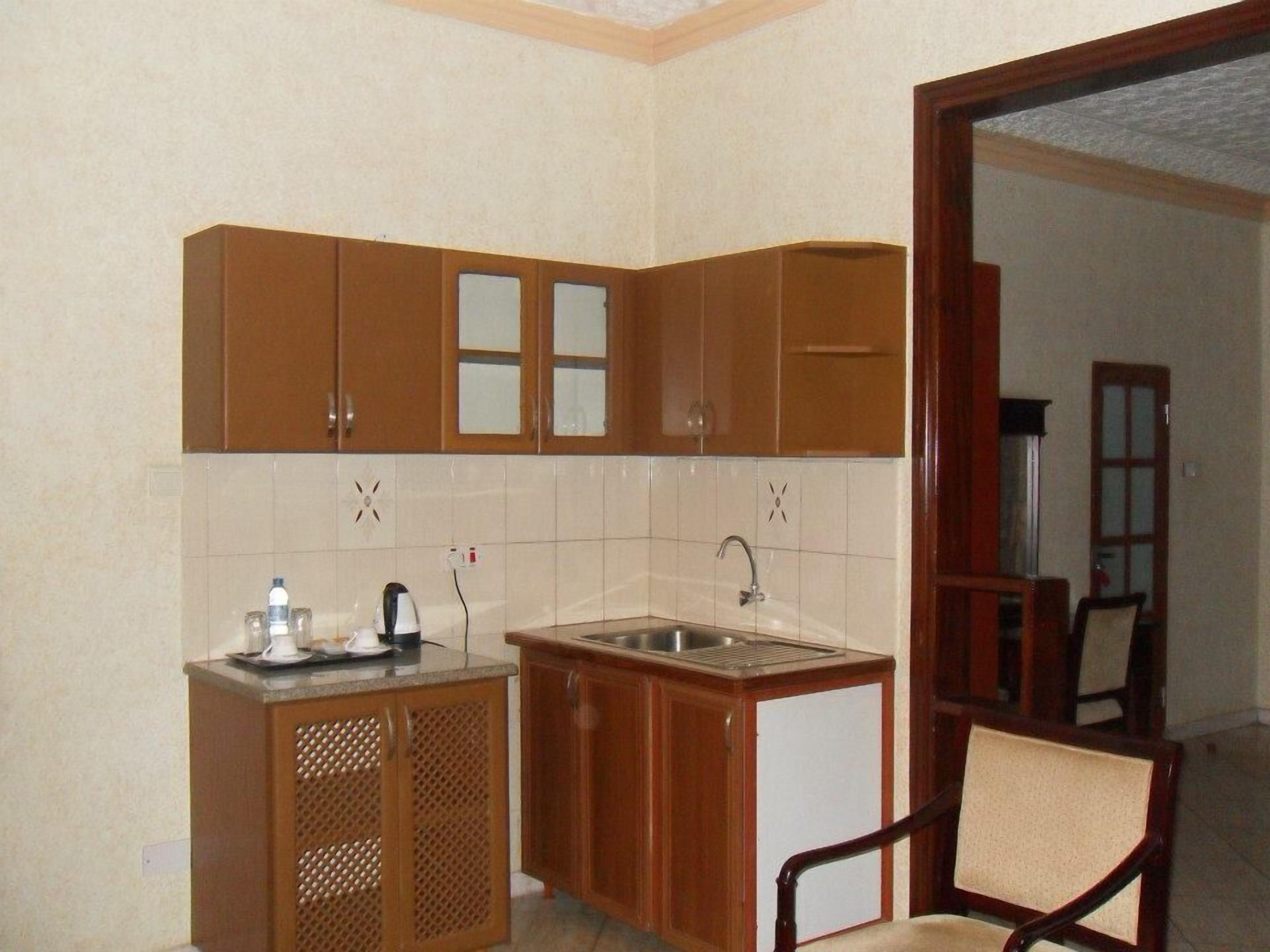 A compact kitchen with wooden cabinets, a sink, and a small countertop.