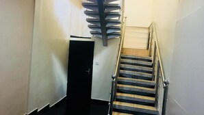 A staircase with a metal handrail and a black door at the top. - Esporta Hotel Yaba (Lagos)