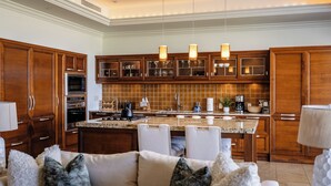 Een moderne keuken met houten kastjes, een centraal eiland en hanglampen.