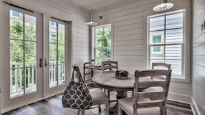 A dining area with a round table, wooden chairs, and a patterned bag. - New construction, custom decorated, chic and spacious Seacrest home, sleeps 14 (Rosemary Beach)