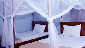 A room with two single beds, each with a wooden headboard and white bedding. - Jaguar Guest House (Kampala)