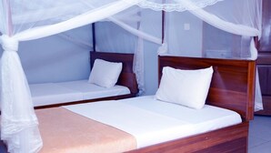 A double bed with a wooden frame and a canopy. - Jaguar Guest House (Kampala)