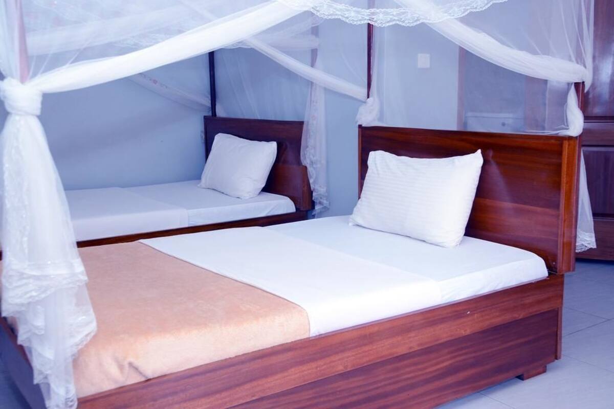 Una cama doble con estructura de madera y dosel.