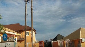 Una vista de carrer amb un edifici groc, un rètol de 'LAUREL' i un senyal amb una 'ESTRELLA'.